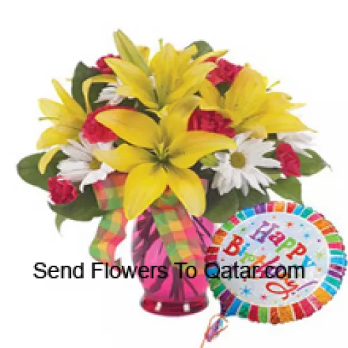 Oeillets rouges, lys jaunes et gerberas blancs dans un vase en verre accompagnés d'un ballon d'hélium "anniversaire"