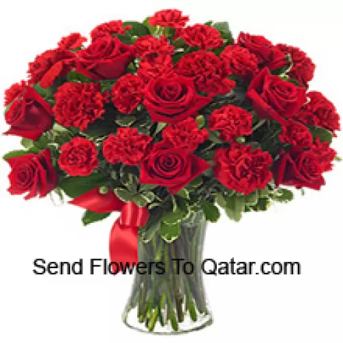 12 Red Roses And 12 Red Carnations With Some Ferns In A Glass Vase