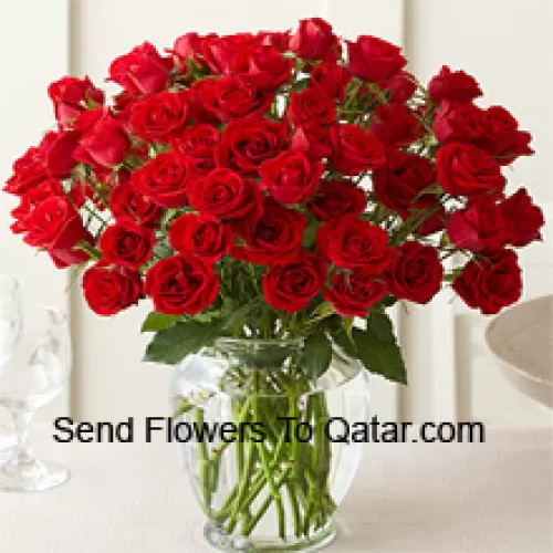 50 Roses Rouges Avec Quelques Fougères Dans Un Vase en Verre