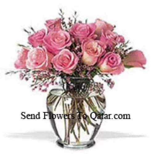 Bouquet de 12 roses roses avec quelques fougères dans un vase